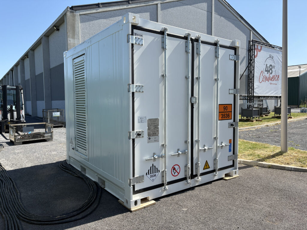 Container de stockage d'énergie Alfen blanc avec pictogrammes de sécurité UN 3536 installé en extérieur – location batterie grande capacité Revolt Location