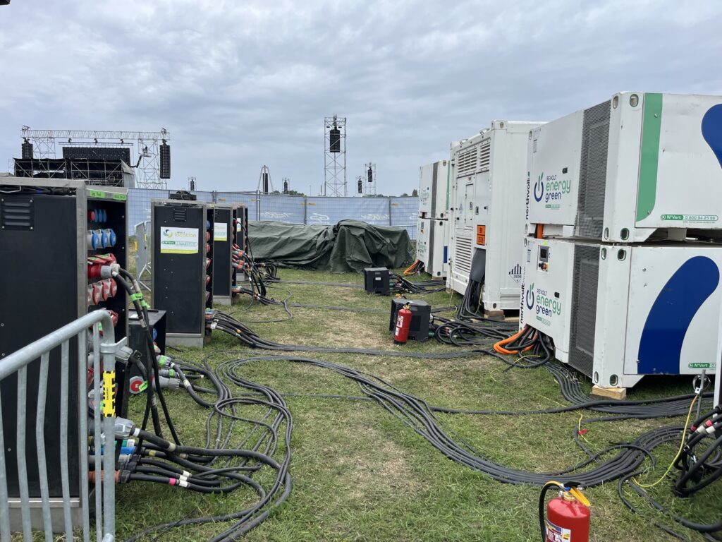 Zone technique GP Explorer : packs batterie Revolt Energy Green, armoires de distribution et câblage déployés en backstage festival
