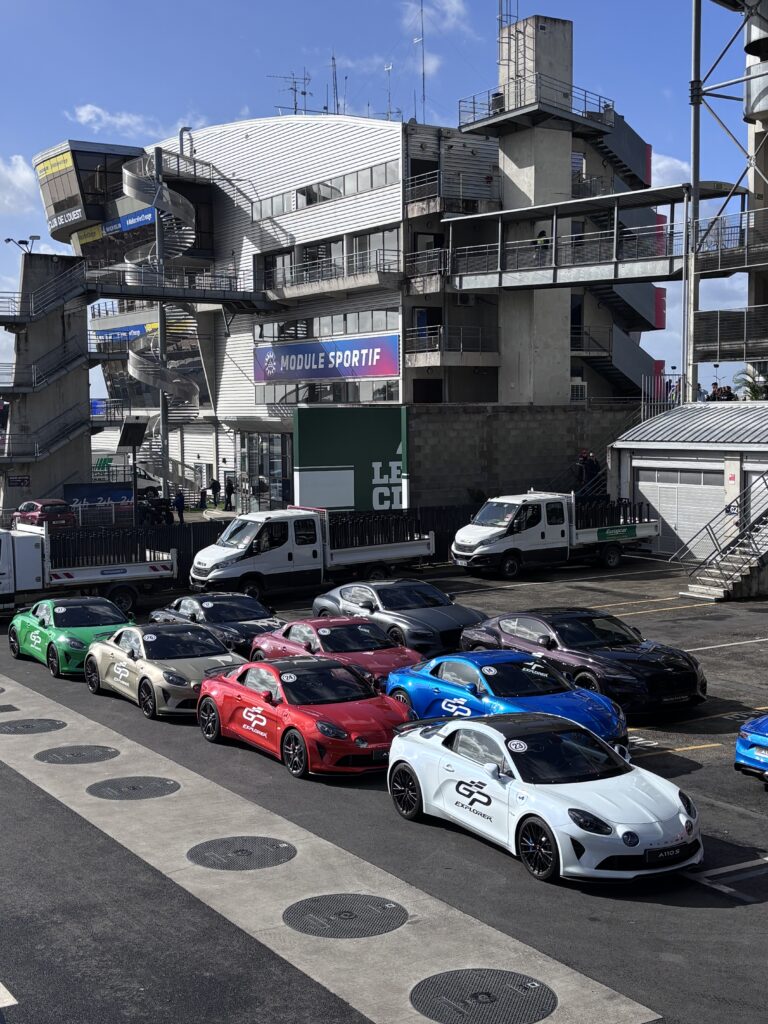 Parc de véhicules Alpine A110 GP Explorer alignés dans les paddocks du circuit des 24h du Mans – événement automobile soutenu par Revolt Location