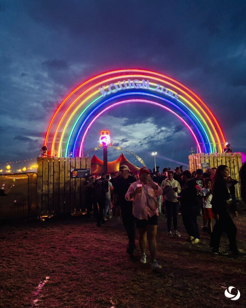 Entrée d’un événement en plein air avec arche lumineuse multicolore et public