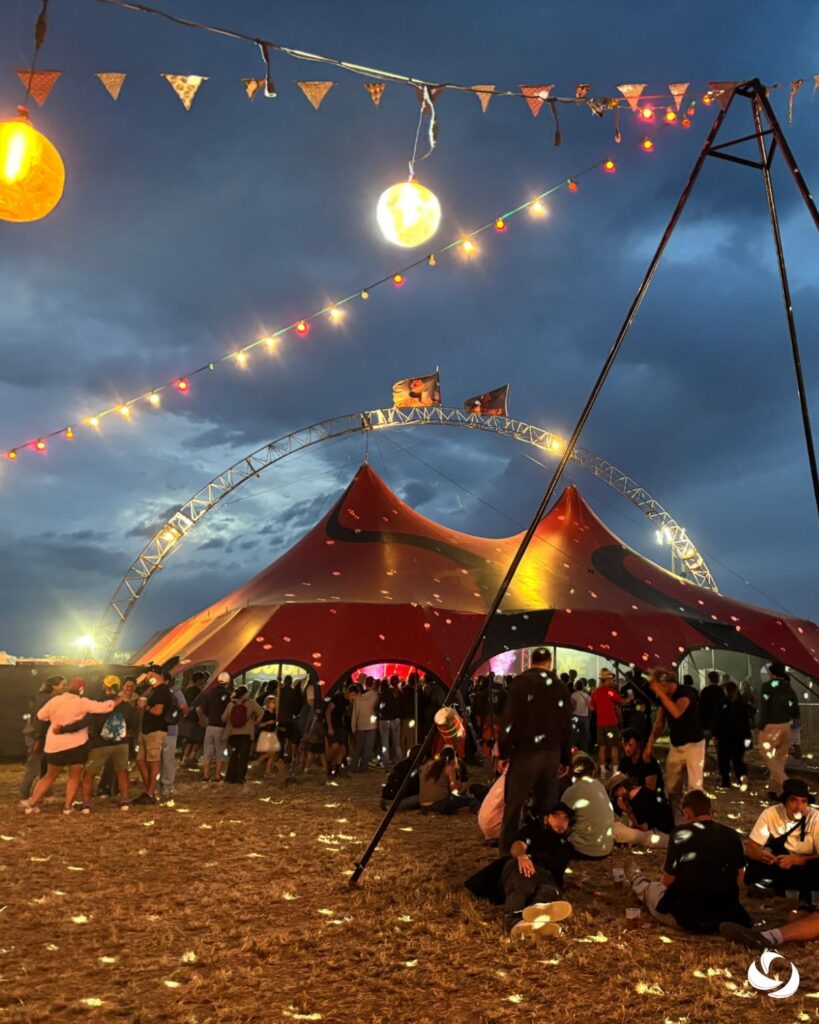Éclairage décoratif et tente événementielle accueillant le public lors d’un festival en plein air