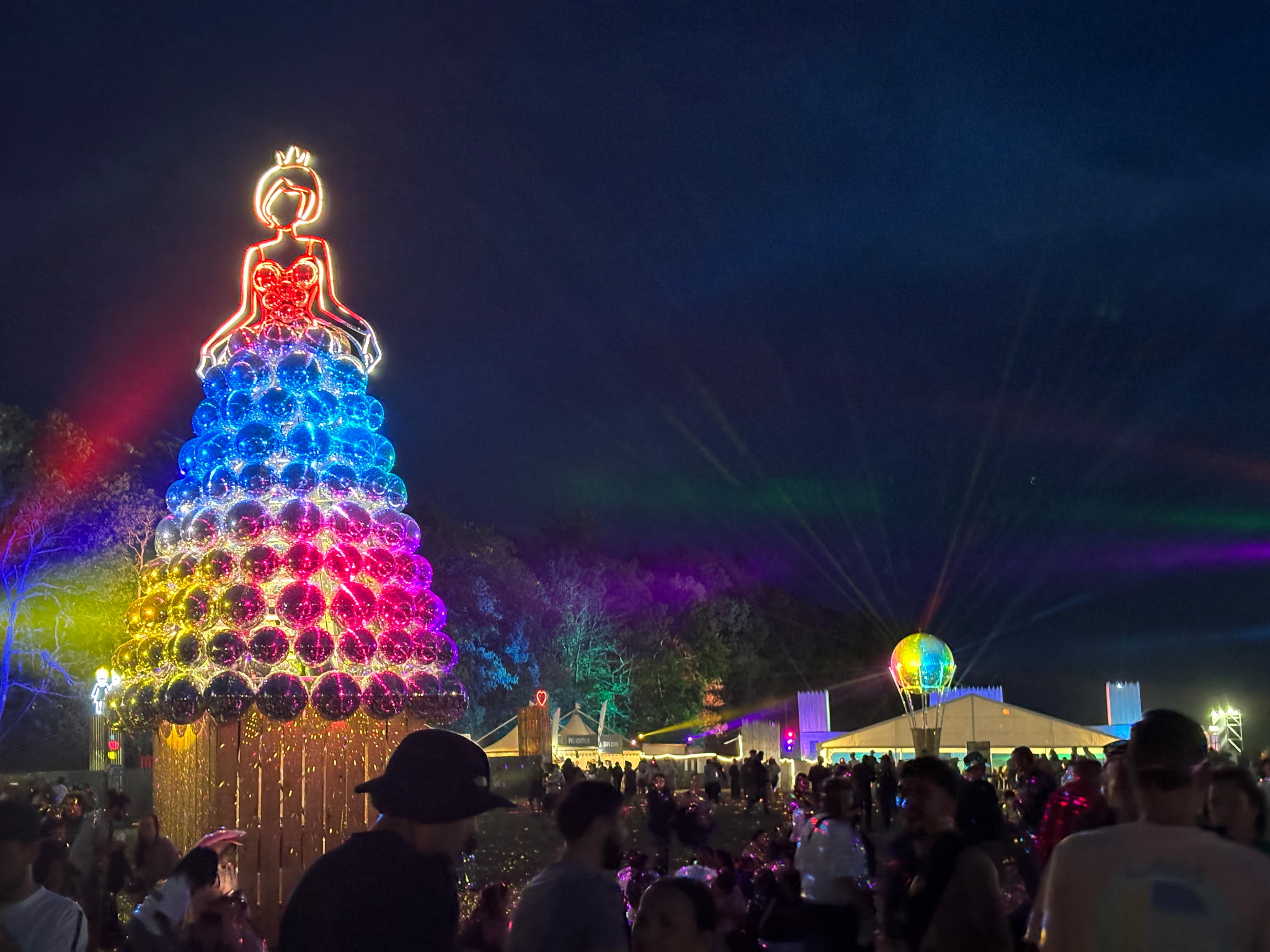 Mise en lumière d’un espace événementiel nocturne avec arbre décoratif lumineux et projecteurs colorés